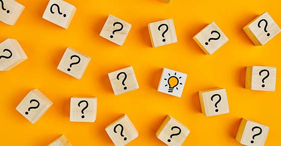 Concept of to find a creative idea or problem solving. Question mark and light bulb icons on wooden cubes on yellow background. | Dalby Wendland & Co. | CPAs and Business Advisors | Grand Junction CO | Glenwood Springs CO | Montrose CO 