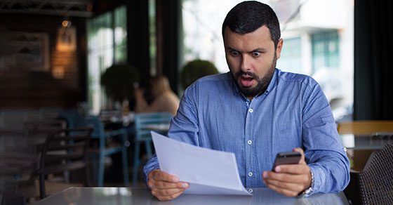 man looking surprised at piece of paper | Check Your Withholding to Mitigate Tax Surprises | Dalby Wendland & Co. | CPAs | Business Advisors | Grand Junction CO | Glenwood Springs CO | Montrose CO 